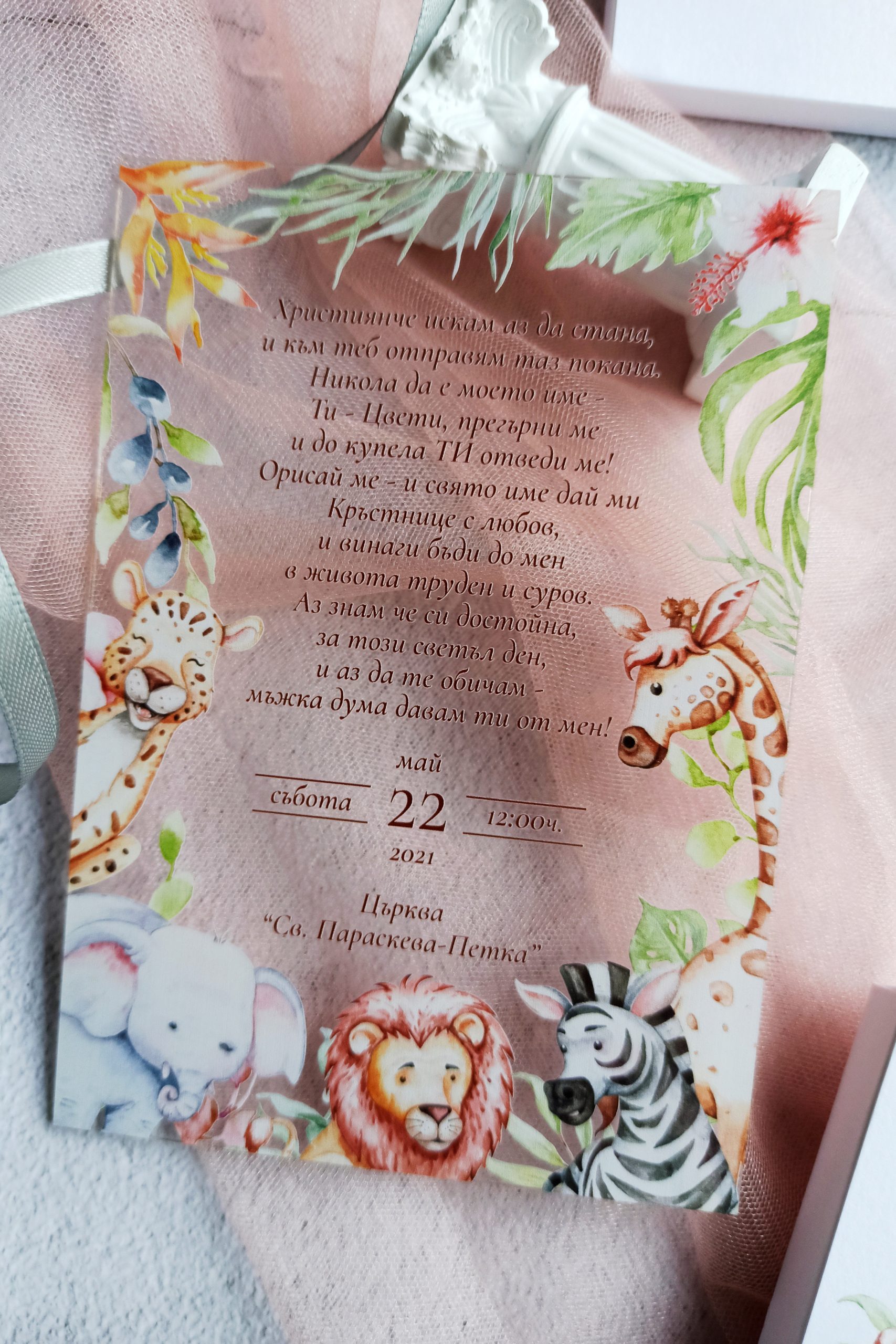 Стъклена покана за кръщене Джунгла изработена от прозрачен плексиглас. Поканата е с дизайн на животни слончета, жираф, зебра и зелени листа. Те са разположени като рамка по цялата покана. Централно е изписан текстът за събитието в кафяв цвят. Подходяща е за кръщене на момче и момиче, както и за детски рожден ден.
